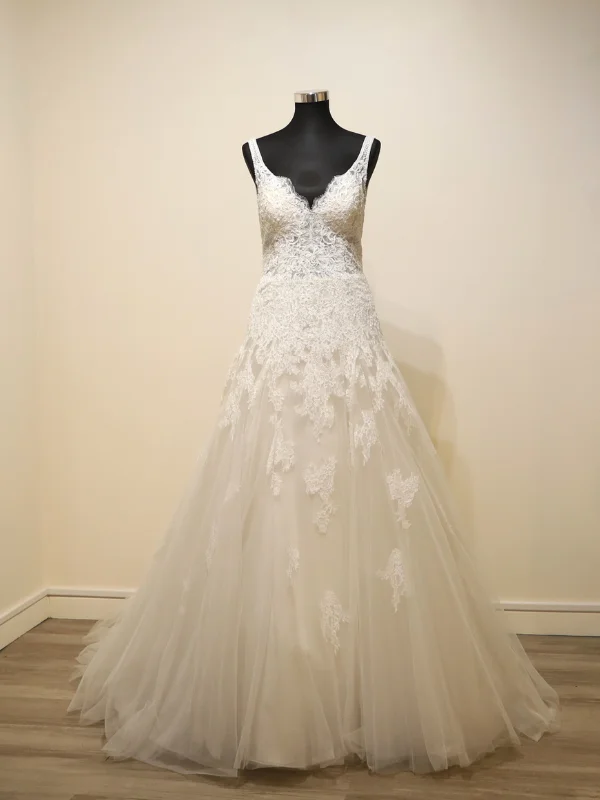 Robe de mariée princesse modèle Concord par Rosa Clara, présentée de face sur portant, mettant en évidence le bustier travaillé en dentelle et le volume de la jupe.
