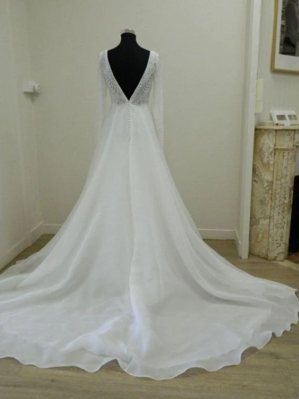 Vue de dos de la robe de mariée princesse Sira d'Aire Barcelona avec sa grande traîne en organza au showroom de Tours.