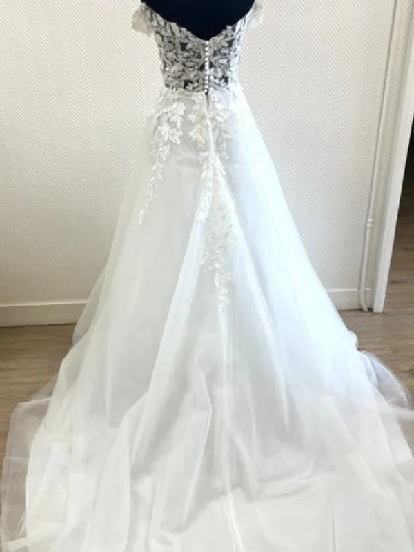 Vue de dos de la robe de mariée princesse modèle Premice en showroom, détails du boutonnage et de la dentelle, taille 46