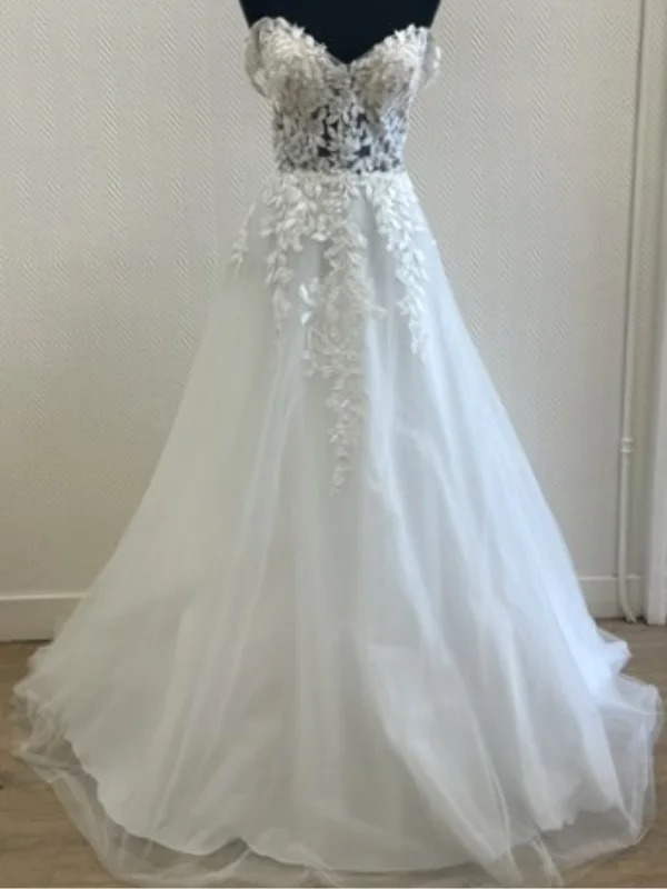Robe de mariée princesse modèle Premice sur mannequin en showroom, vue de face, détails de la dentelle et jupe en tulle