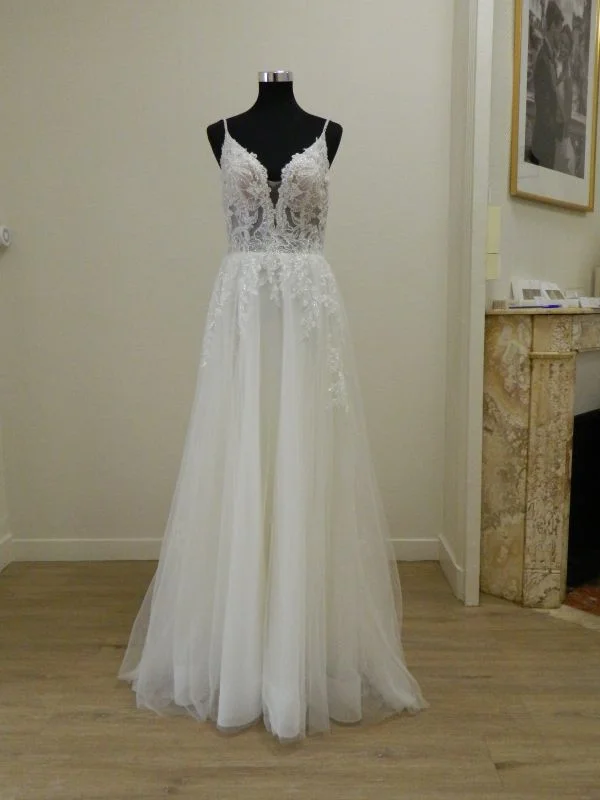 Photo technique de face de la robe de mariée princesse en tulle blanc 23236 de Très Chic sur mannequin de couture dans un showroom, avec fines bretelles et décolleté en V plongeant.