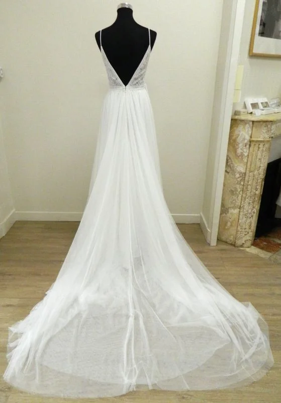 Robe de mariée princesse Ululan de Rosa Clará vue de dos, dévoilant un profond décolleté en V plongeant et une longue jupe vaporeuse en tulle avec traîne.