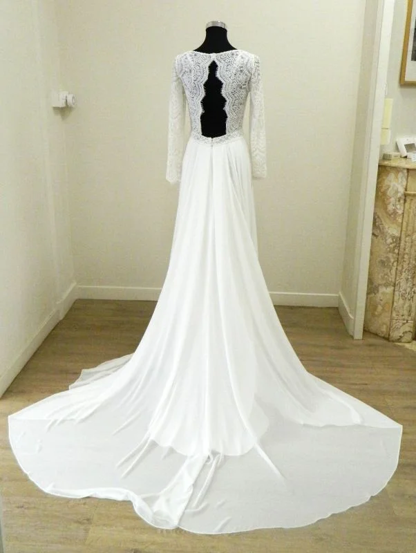 Robe de mariée trapèze Darcy de Rosa Clará vue de dos sur mannequin, mettant en valeur des manches longues en dentelle, un dos nu graphique en trou de serrure et une longue traîne fluide en mousseline.