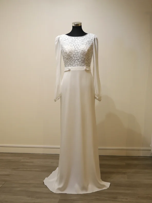 Vue technique de face de la robe de mariée trapèze Rosa Clara modèle Urim sur mannequin, montrant la structure du bustier en dentelle, les manches longues et la coupe épurée.