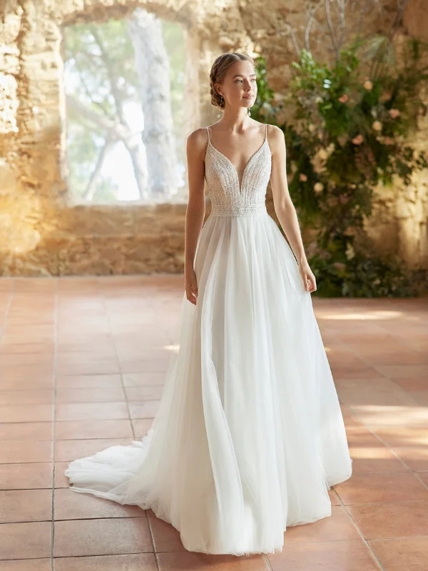 Vue de face de la robe de mariée trapèze Alma Novia modèle Rufina, mettant en valeur son bustier travaillé, ses fines bretelles et sa jupe en tulle vaporeux.
