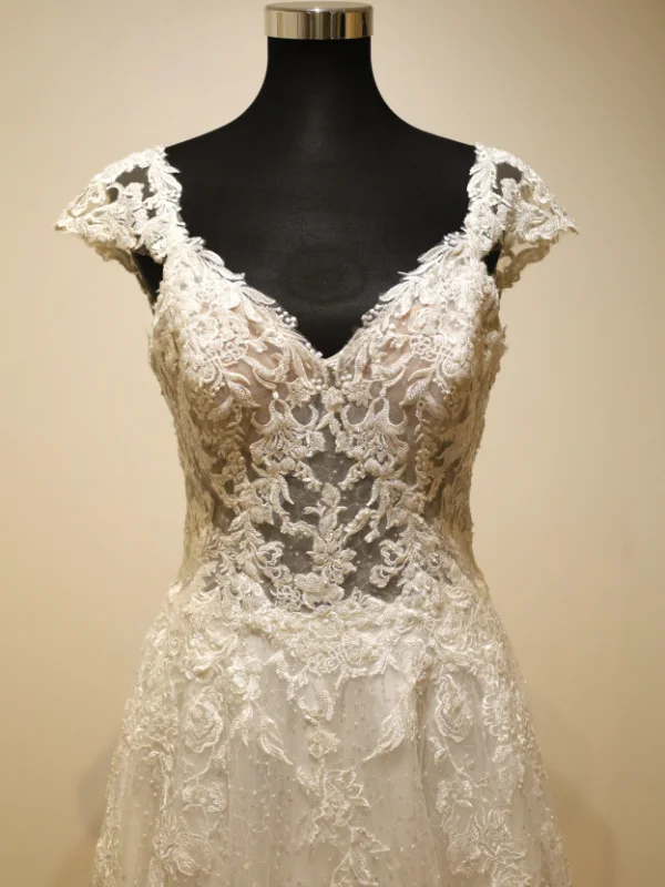 Gros plan sur le bustier en dentelle travaillée de la robe de mariée Très Chic modèle 23237, mettant en valeur les détails floraux et le galbe raffiné du décolleté.
