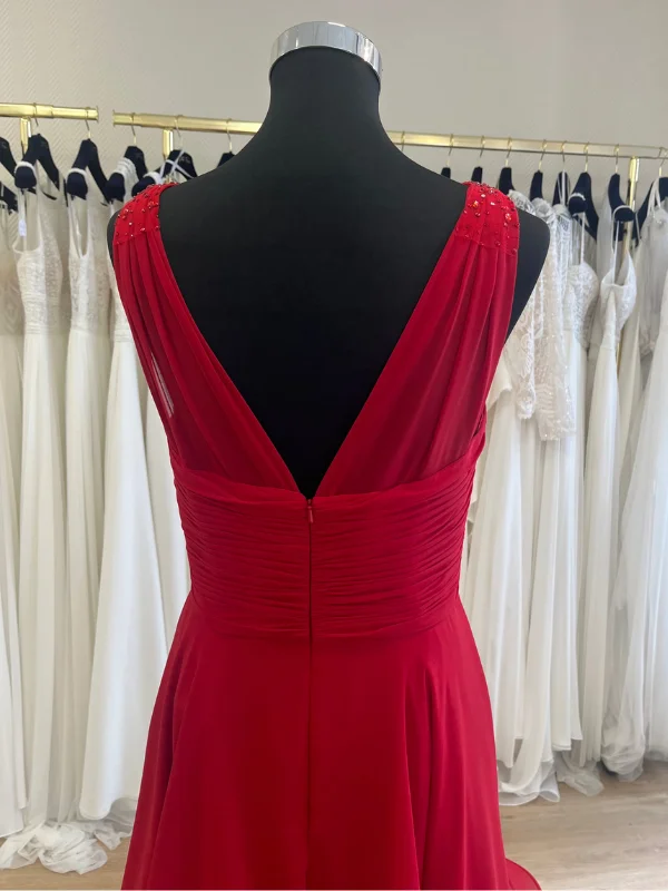 Plan rapproché du dos nu en V d'une robe de cocktail rouge élégante, présentée dans un showroom, mettant en évidence les détails de couture.