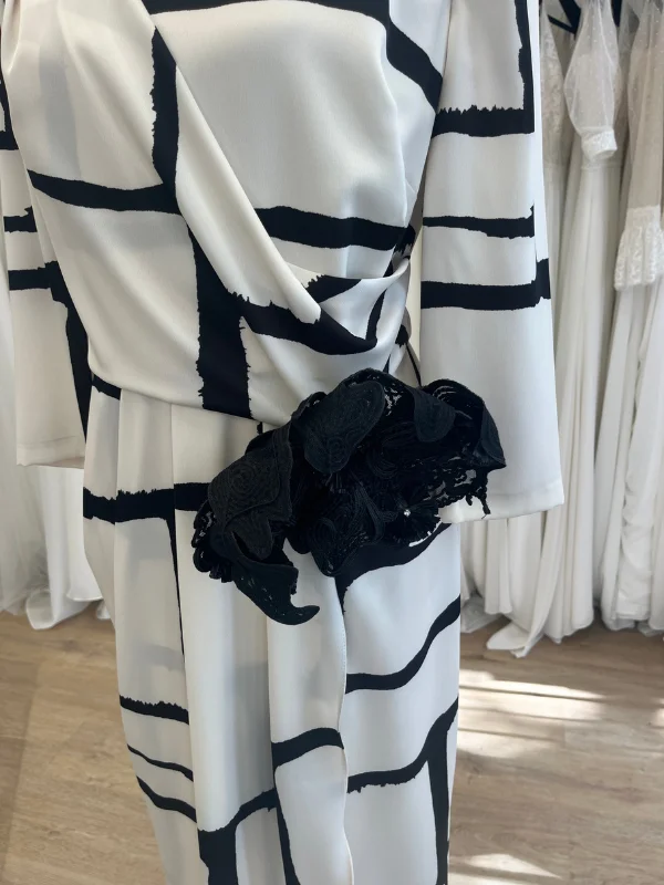 Gros plan sur la fleur noire décorative et le drapé à la taille de la robe de cocktail Carla Ruiz 196560