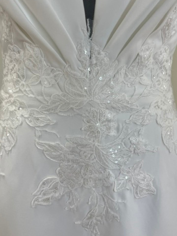 Gros plan sur les détails de la dentelle florale perlée et brodée au niveau de la taille de la robe de mariée Racquel 11349