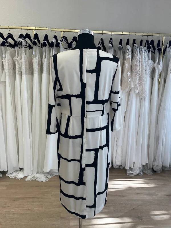 Vue de dos de la robe de cocktail Carla Ruiz modèle 196560 à motifs géométriques, présentée en showroom