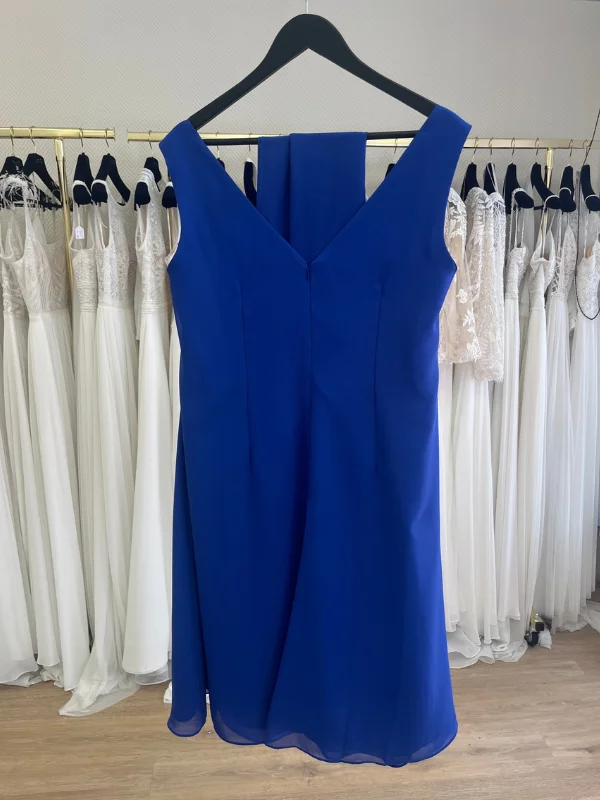 Vue de dos de la robe de cocktail bleu royal RO647 Créatif Paris, présentée sur cintre dans un showroom, mettant en avant sa coupe épurée.
