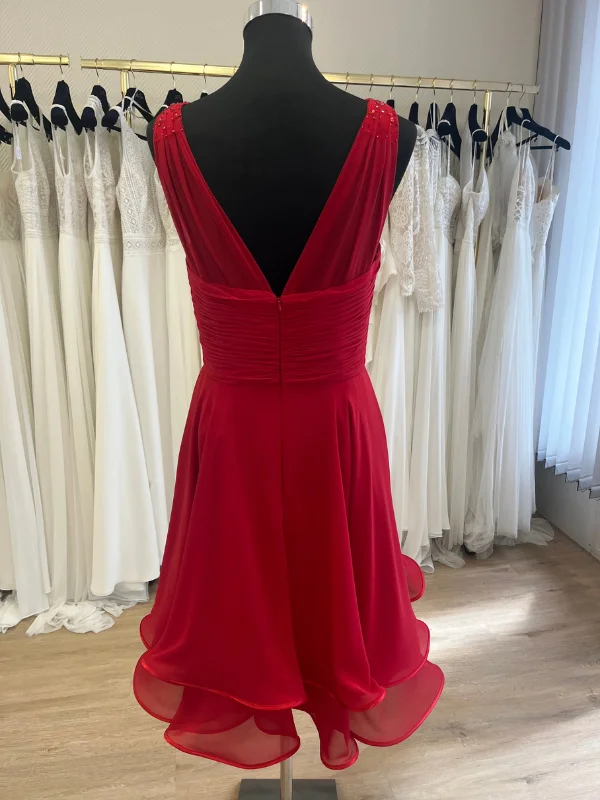 Vue de dos de la robe de cocktail courte rouge R058C Créatif Paris, présentant un décolleté dos en V et une jupe à volants, vue dans un showroom.