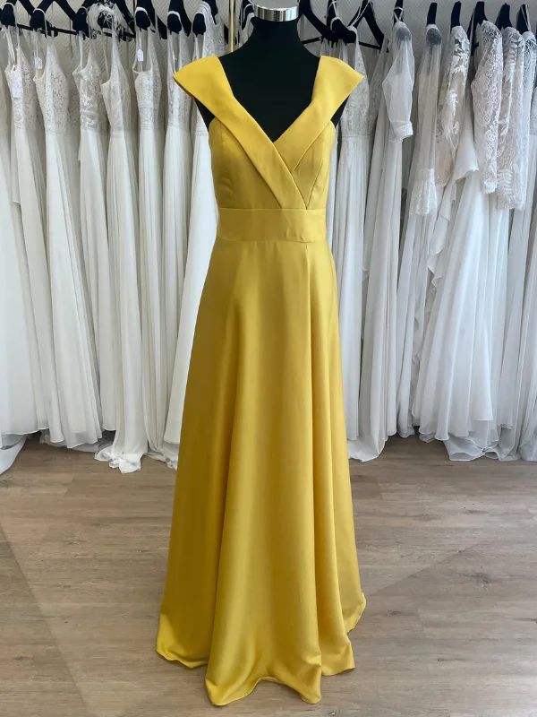 Robe de cocktail jaune R0656 Créatif Paris, présentée sur cintre dans un showroom, vue de face.