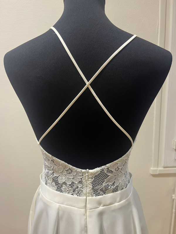 Gros plan sur le dos nu croisé et la dentelle délicate de la robe de mariée courte Rita par Te Amo, détails des finitions, taille 38, Petite Folie Mariage.
