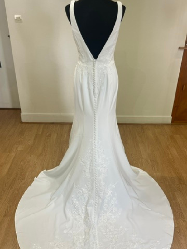Vue de dos de la robe de mariée fourreau Racquel 11349, décolleté plongeant et boutons, présentée dans le showroom Petite Folie Mariage