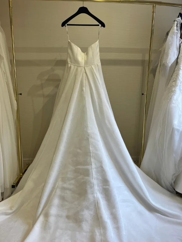 Vue de dos en showroom de la robe de mariée princesse Susanna Rivieri 314638 avec sa traîne en organza