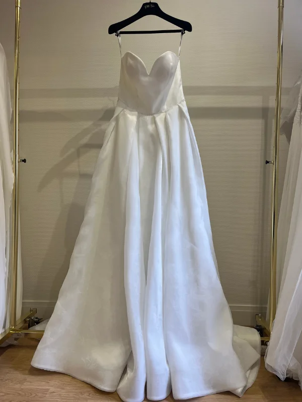 Vue de face en showroom de la robe de mariée princesse Susanna Rivieri modèle 314638 en organza sur cintre