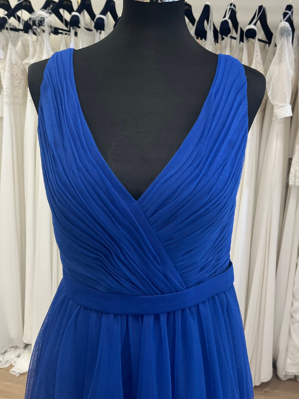 Gros plan en showroom du corsage plissé en V de la robe de cocktail midi bleu royal NY2783 de Fashion New York sur mannequin.