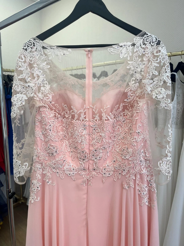 Gros plan en showroom du haut du dos de la robe de cocktail rose blush NY2819 de Fashion New York : dentelle brodée avec strass, tulle transparent illusion et fermeture éclair discrète.