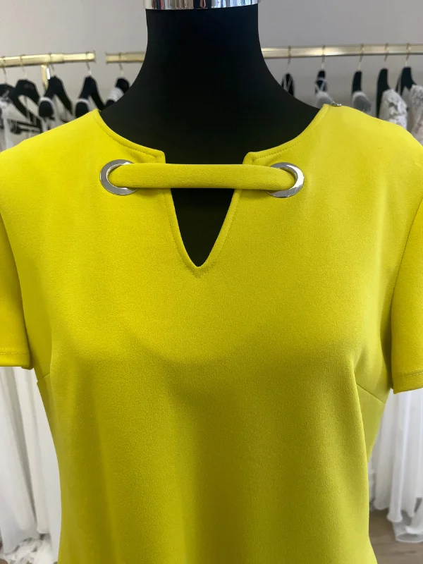 Gros plan en showroom de l'encolure de la robe de cocktail jaune lime 196595 de Frank Lyman : œillets métalliques argentés, bride horizontale et découpe goutte d'eau.