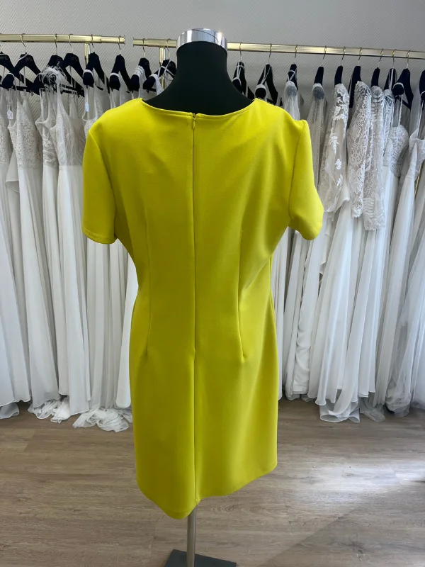 Photo en showroom du dos de la robe de cocktail courte jaune lime 196595 de Frank Lyman présentée sur mannequin couture.
