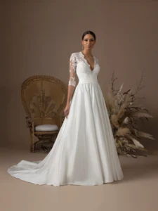 Robe de mariée princesse Dorit d'Atelier Nuptial en satin avec bustier en dentelle et manches trois-quarts, vue de face.