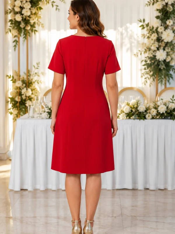 Photographie de dos d'un mannequin posant dans la robe de cocktail rouge Carla de Sonia K. La robe présente une coupe ajustée avec une fermeture éclair invisible au centre du dos, des emmanchures nettes et une jupe légèrement évasée arrivant au-dessus des genoux.